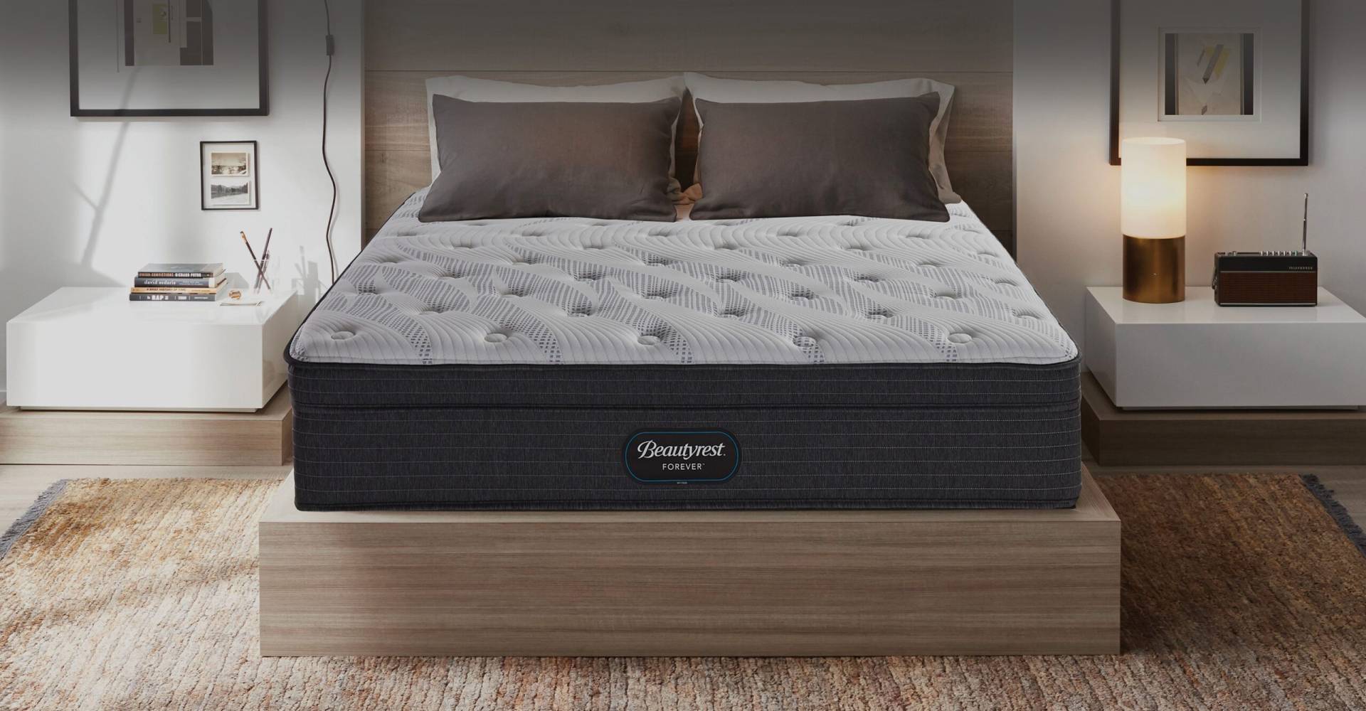 Beautyrest Forever Hybrid mattress in a well-lit bedroom between two bedside tables.